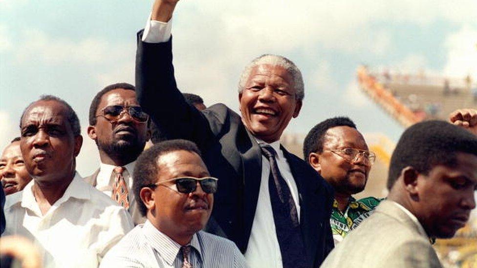 South African National Congress (ANC) President Nelson Mandela gives 15 March 1994 in Mmabatho a clenched fist to supporters upon his arrival for his first election rally for 27 April general elections.