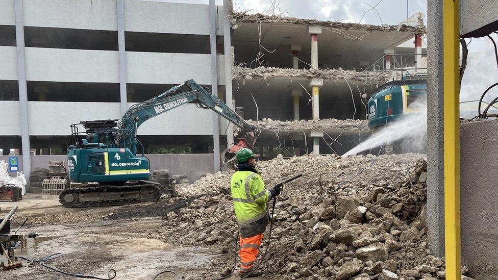 A worker sprays water during construction works