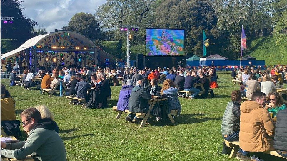 Pobl yn mwynhau Tafwyl yng ngerddi Castell Caerdydd