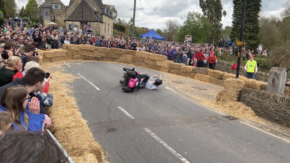 A boy falling out of go-kart in the hairpin bend