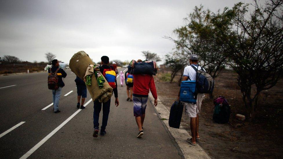 Venezuelan migrants walk alongside a route, after leaving the CEBAF (bi-national border care center) facilities in Tumbes, Peru, near the border with Ecuador, on November 01, 2018.