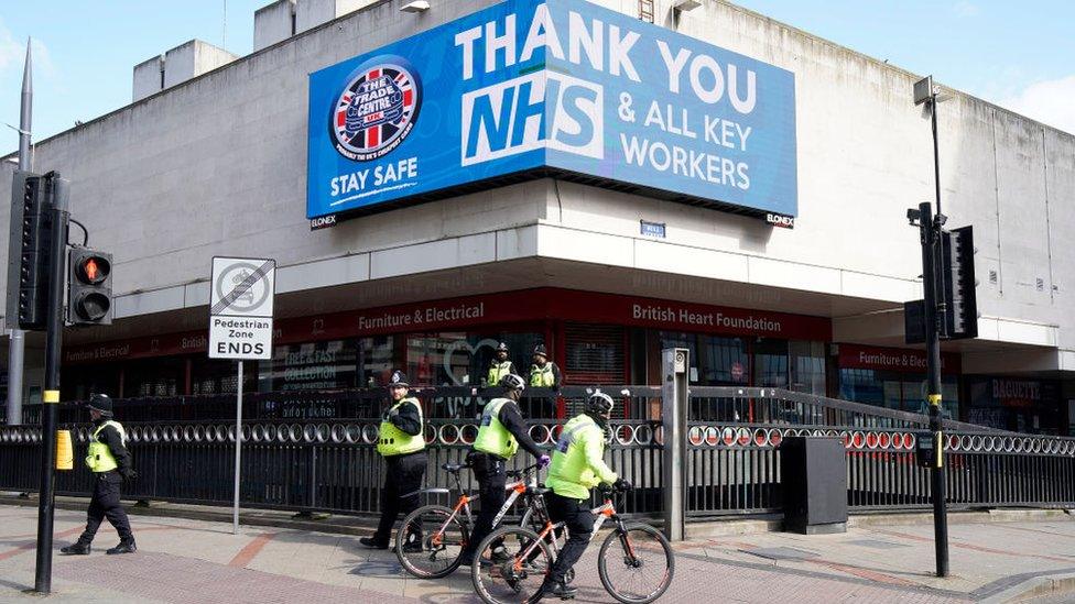 Police officers patrol a deserted Corporation Street in Birmingham city centre during the nationwide lockdown on March 29, 2020