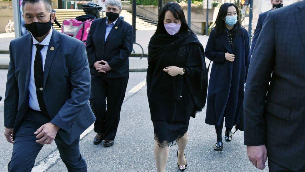 Huawei Chief Financial Officer, Meng Wanzhou (C) leaves the British Columbia Supreme Court with her security detail in Vancouver, British Colombia on March 22, 2021.