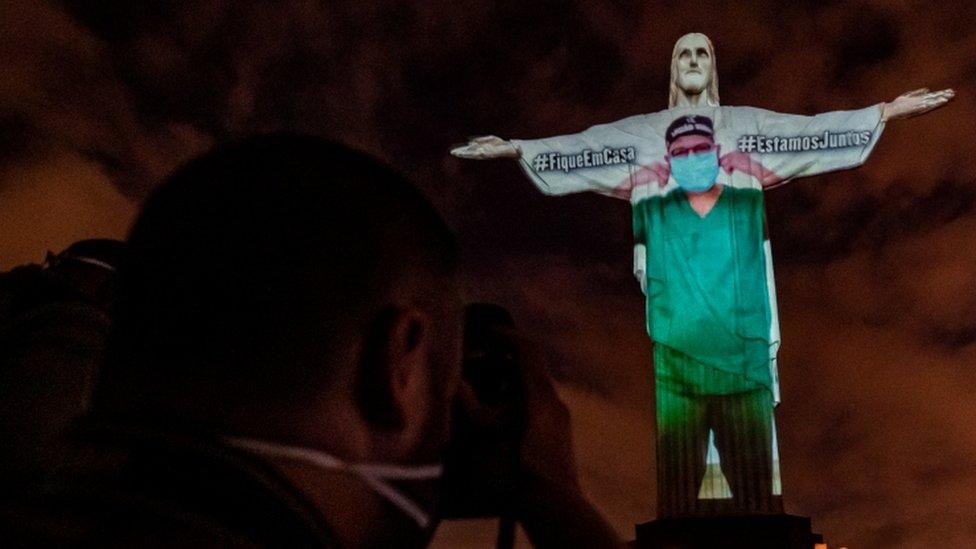 View of the illuminated statue of Christ the Redeemer with an image of a doctor projected onto it