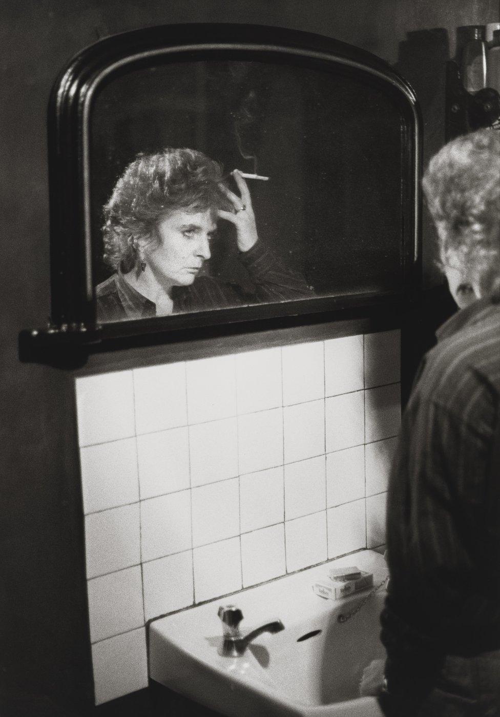 Maggi Hambling stands at the sink, 1984