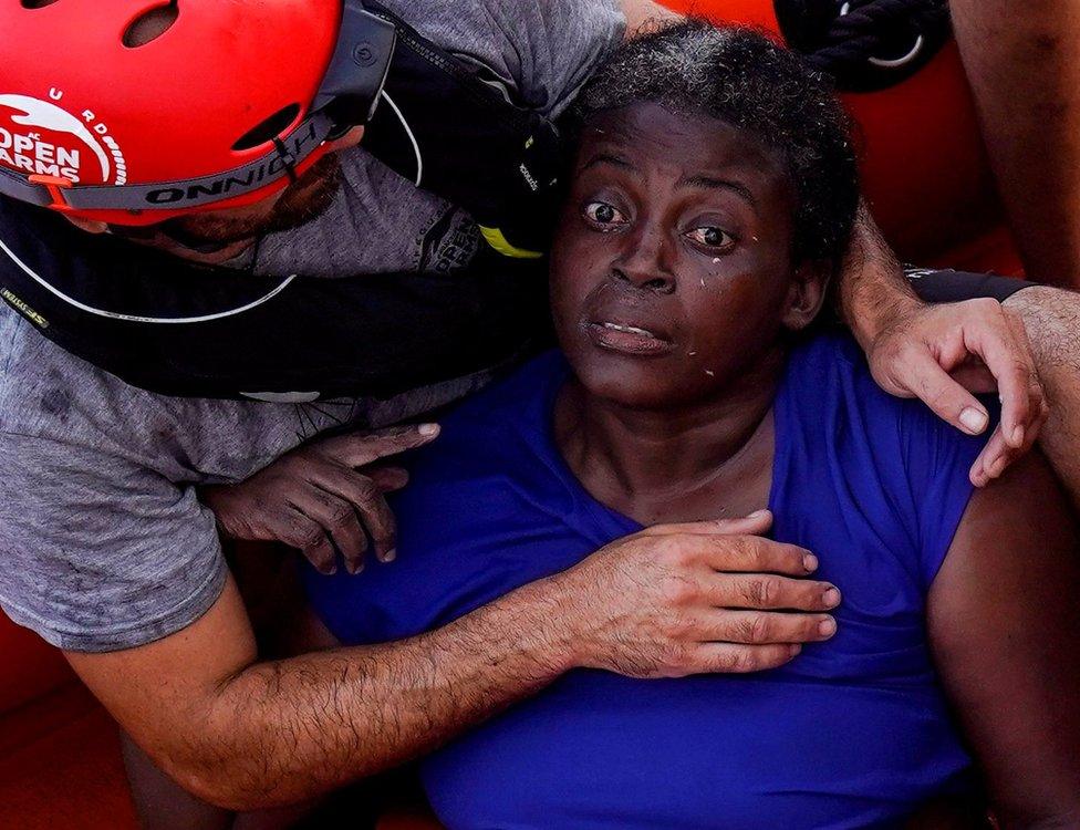 A crew member of NGO Proactiva Open Arms rescue boat embraces Josepha from Cameroon in central Mediterranean Sea