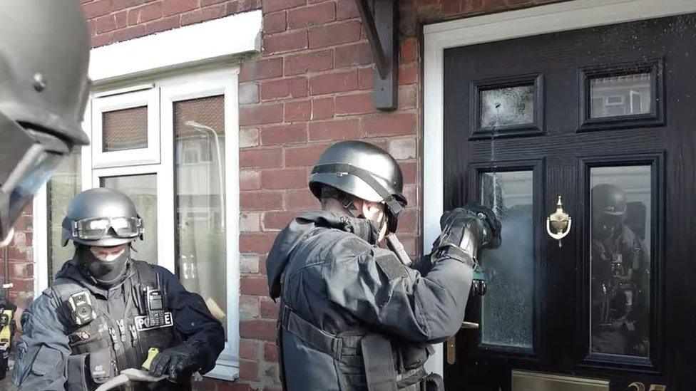 Police officers breaking in to property