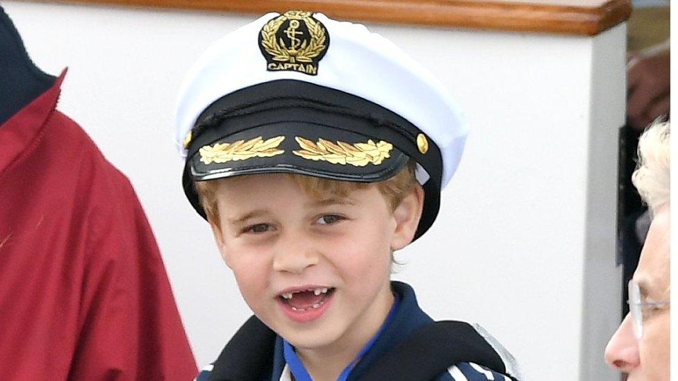 Prince George shows a toothy grin as he cheers on his parents, the Duke and Duchess of Cambridge, during the charity sailing regatta