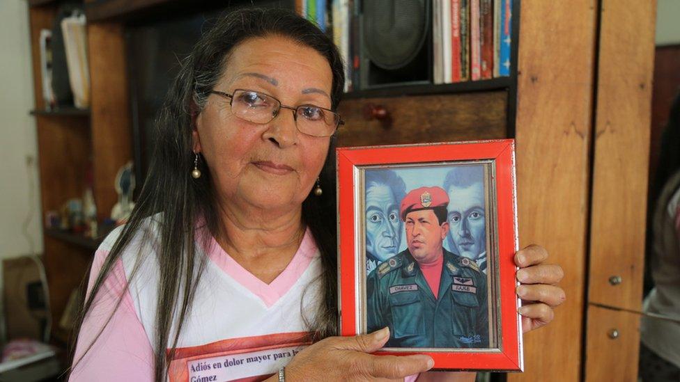 Teresa holds up a painting of President Chávez