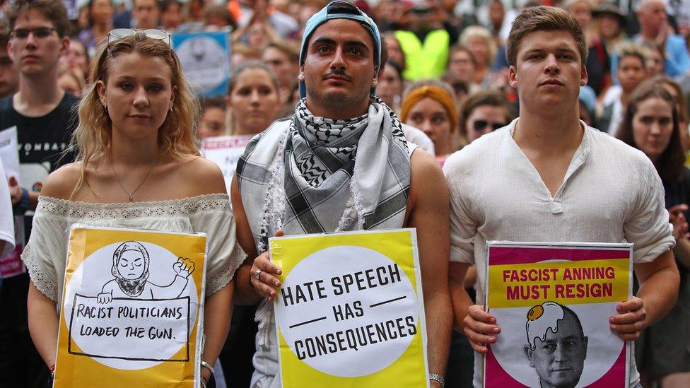 Protesters hold placards condemning "racist politicians" and "Fraser Anning" in an anti-racism rally in Melbourne