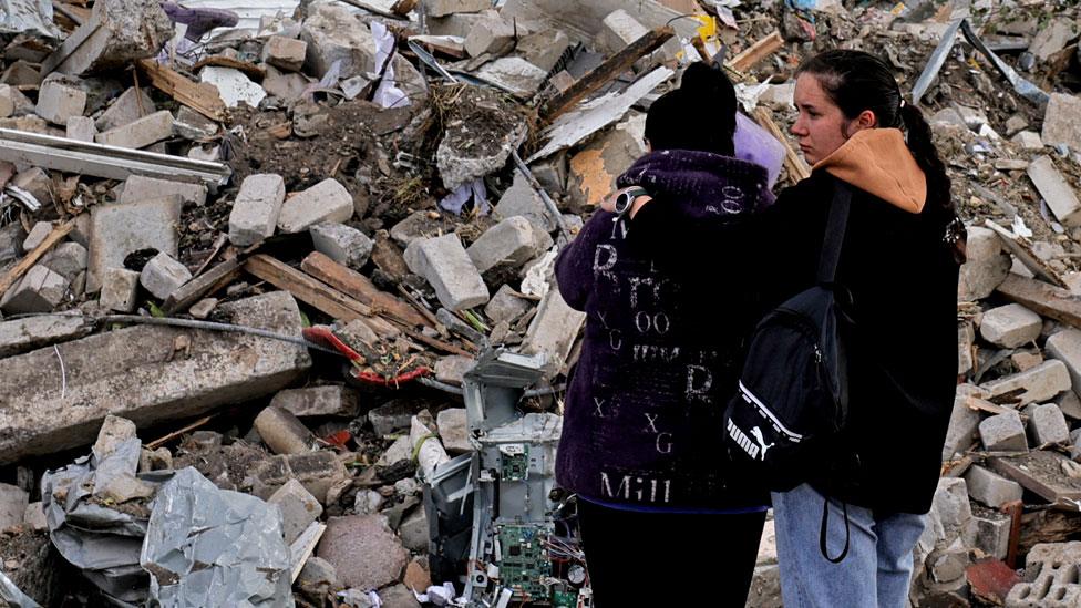 Two women react in front of a pile of rubble that is left of the cafe that hosted the wake and was hit by a Russian missile, following a Russian military strike, amid Russia's attack on Ukraine, in the village of Hroza, Kharkiv region, Ukraine, on 6 October 2023