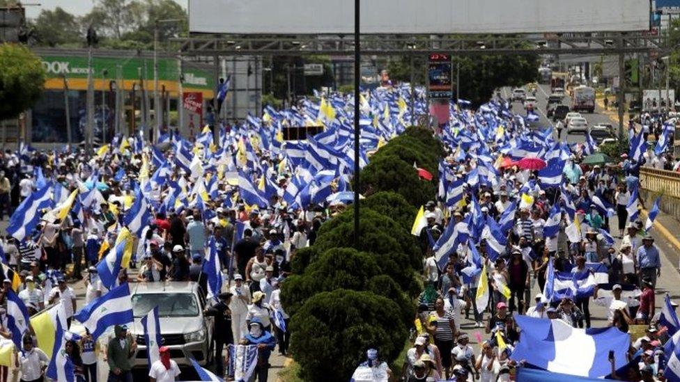 Demonstrators hold national flags during a march in support of the Catholic Church in Managua, Nicaragua July 28, 2018