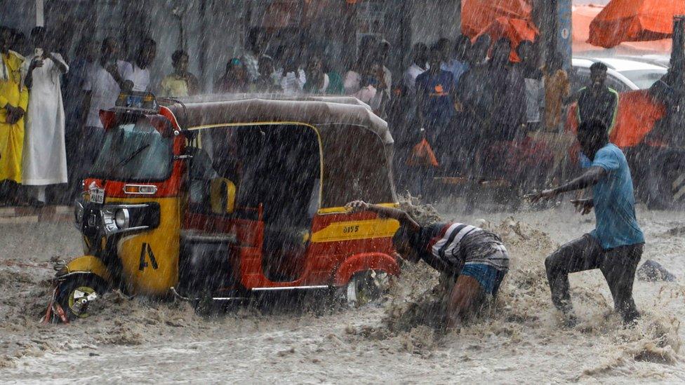 Two men and a rickshaw surrounded by floodwater in Somalia