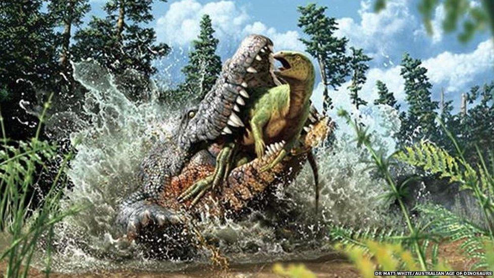 A photo of a crocodile with a small dinosaur in its mouth