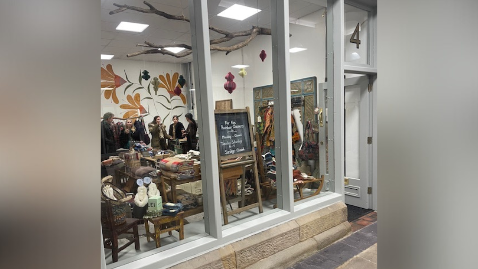 Shop at Glossop Market Hall seen from the outside with people inside