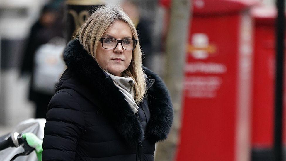 Janet Skinner wearing glasses and a black coat leaving the Post Office inquiry in central London