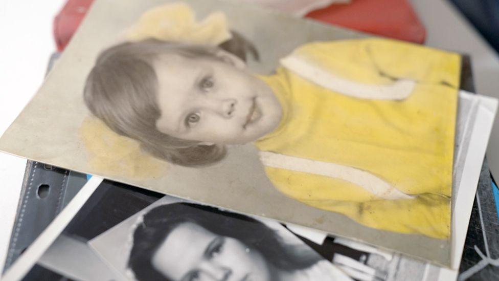 Picture of Francis as a child dressed as a girl, wearing a a yellow top with hair in bunches