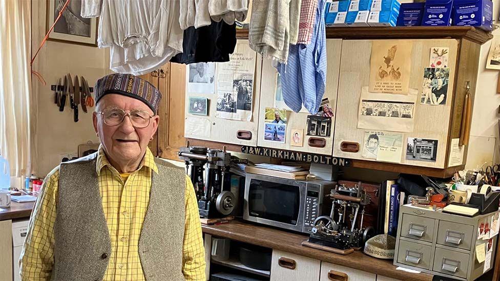 Stanley, now 89, standing in his kitchen, surrounded by mill memorabilia