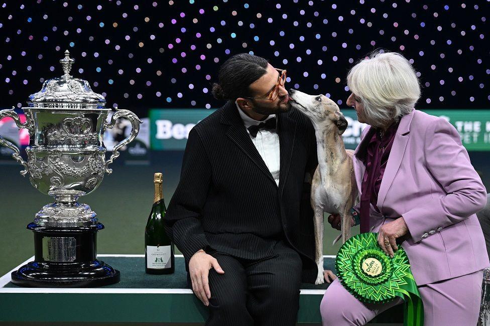 Miuccia, a whippet, poses with owner Giovanni Liguori, from Italy, and judge Patsy Hollings 