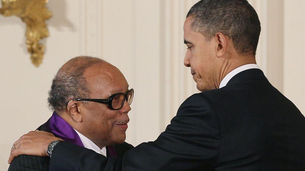 Barack Obama with one hand on Quincy Jones' shoulder during a ceremony to presents the National Medal of Arts in 2011