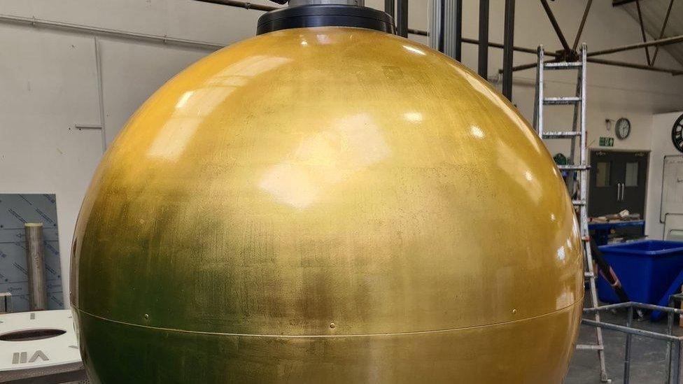 The gold time ball undergoing restoration in a workshop
