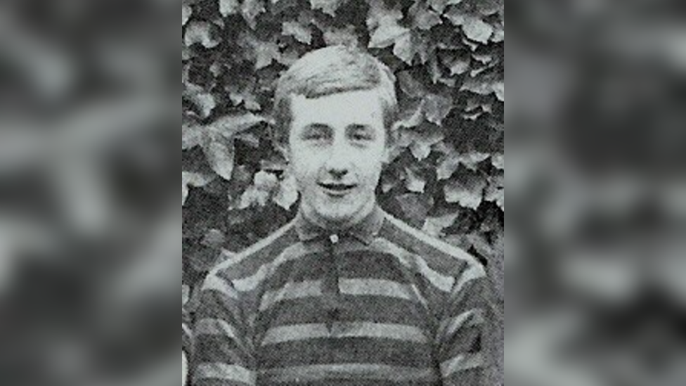 A black and white photo of Fabian Woodley, who is wearing a striped top.