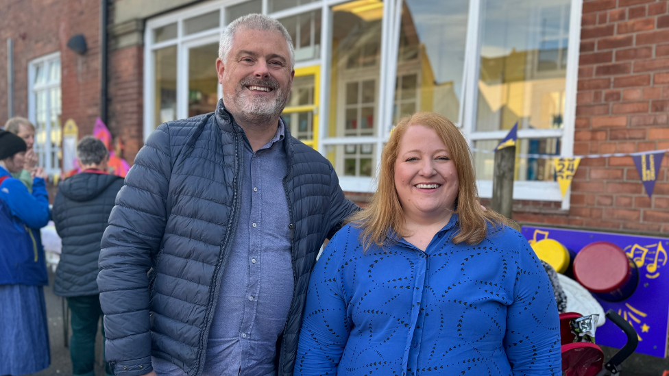 Michael and Naomi Long, both in blue shirts and a blue jacket on Michael pictured at primary school event