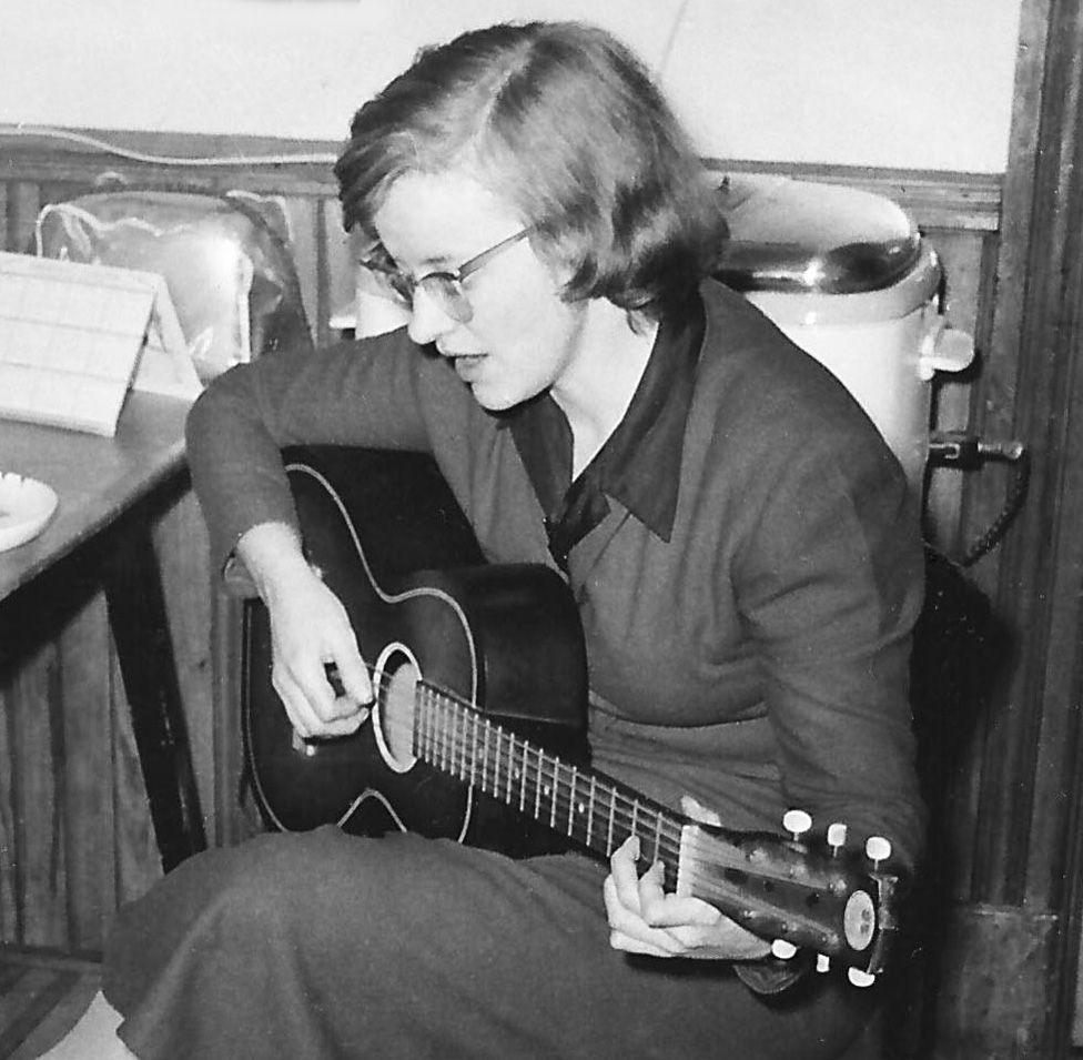 Connie Converse playing an acoustic guitar and singing