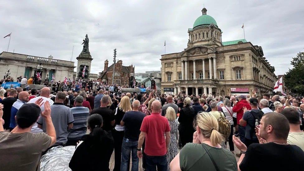 Crowds of people in Queen Victoria Square facing City Hall