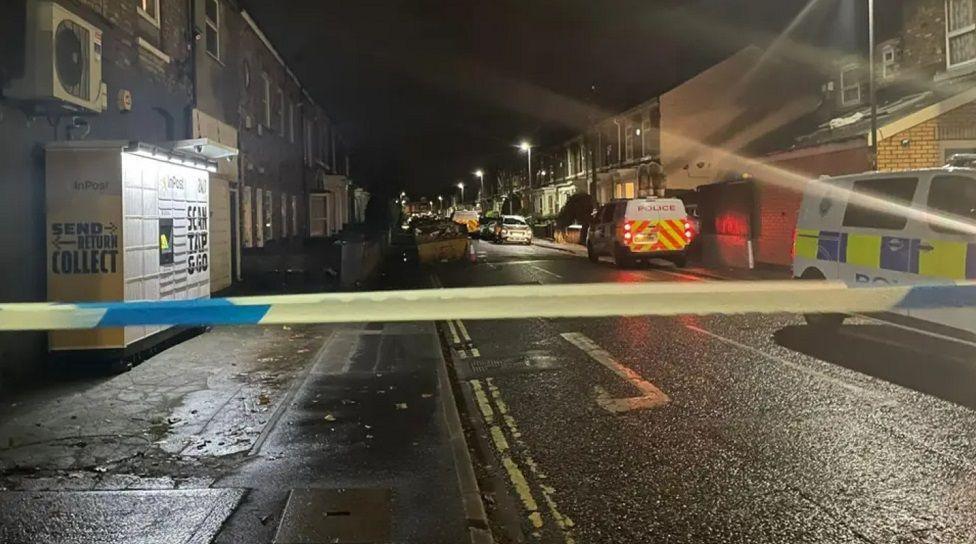 Vyner Street in the Haxby Road area of York with a police cordon in place. Police vehicles are parked down the right-hand side of the street, with police tape stretched across the road.