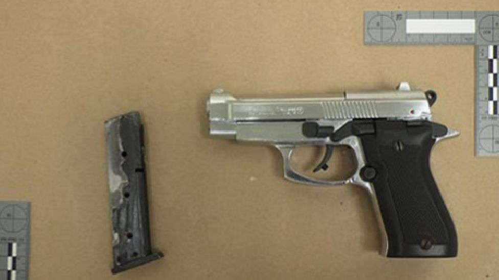 The firearm next to a measuring tape showing its size, taken by police