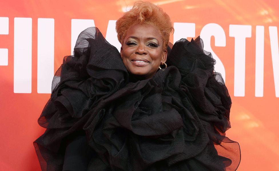 US actor Aunjanue Ellis-Taylor poses on the red carpet for the Nickel Boys gala screening at the BFI London Film Festival - she is smiling and is wearing a black taffeta ruched dress