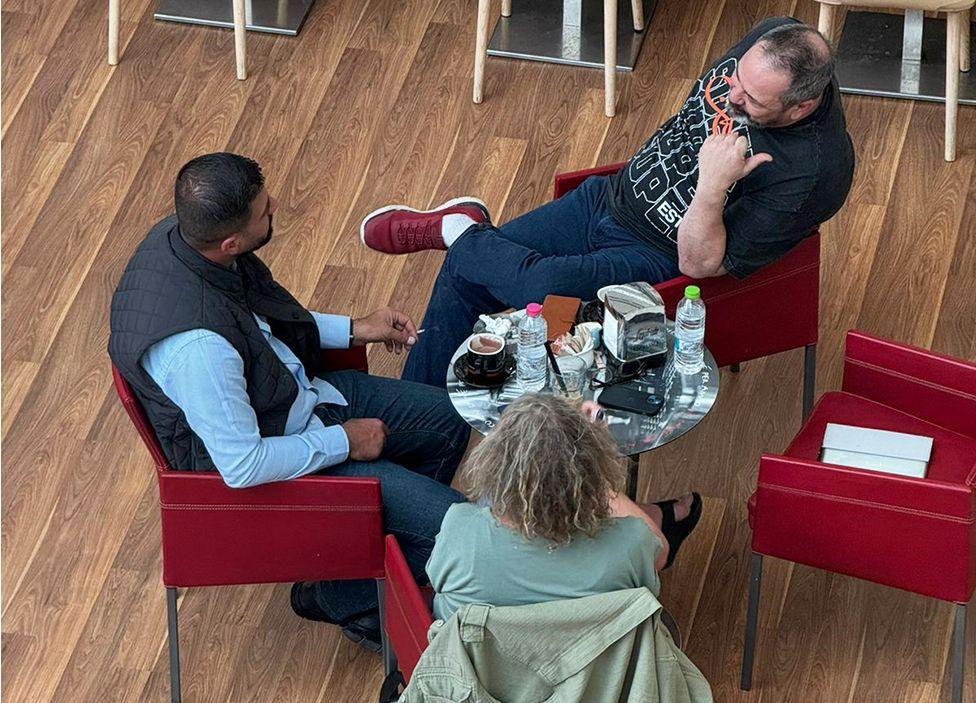 Barzan Majeed (Scorpion) sits round a coffee table with Sue Mitchell and Rob Lawrie