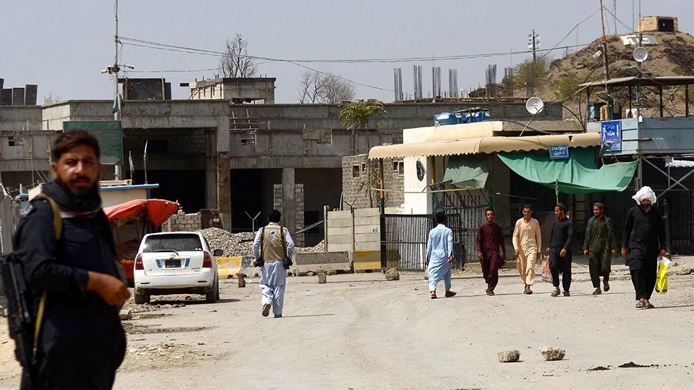 People wait by the key border crossing as trucks carrying goods destined for Afghanistan line up, following clashes between security forces of Pakistan and Afghanistan, in Torkham, Pakistan on September 07, 2023