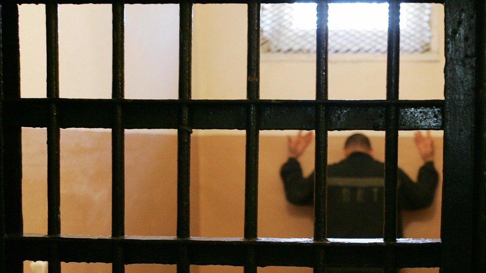 Prisoner facing the wall in a cell