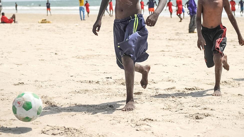 Boys playing football on a beach in Mogadishu, Somalia