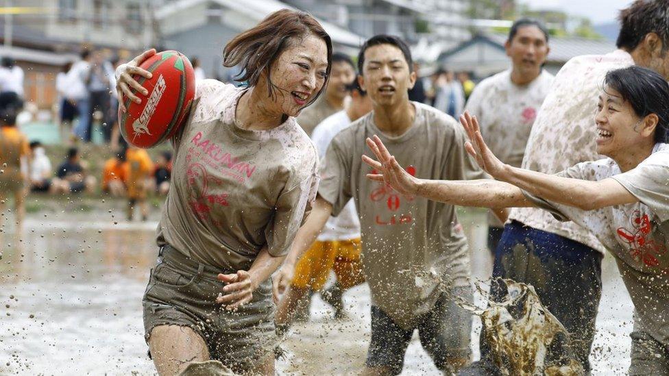 Players slosh through a game of tambo rugby in Kyoto, western Japan