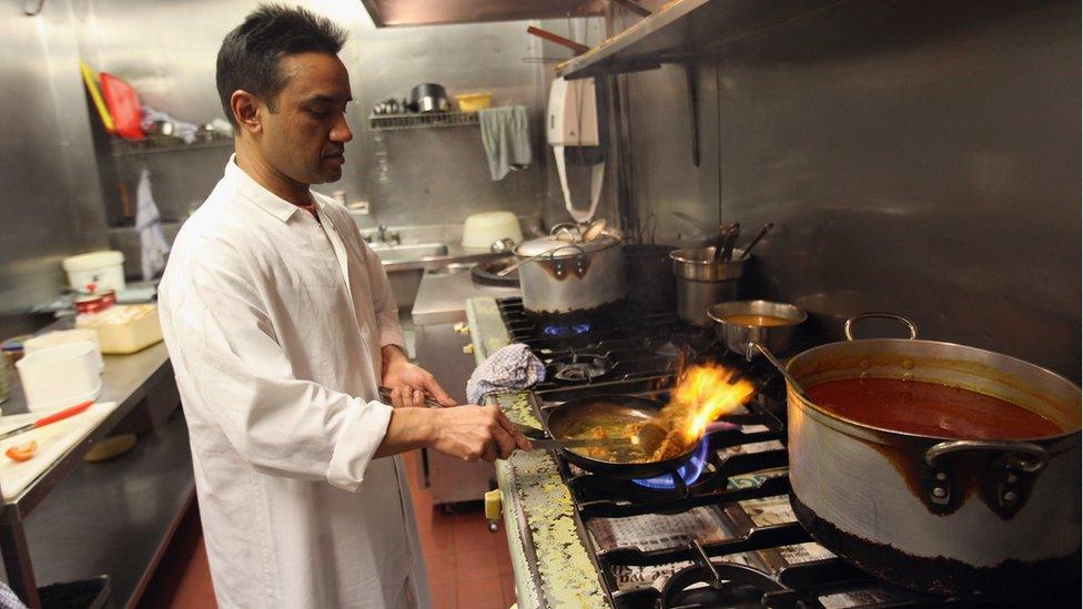 A chef in the UK cooking curry