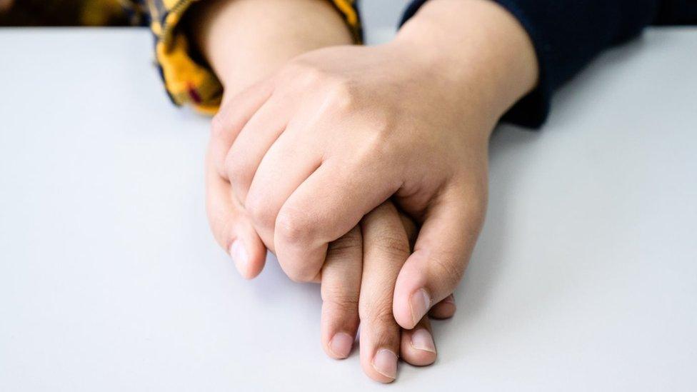 The two sisters hold each other's hand