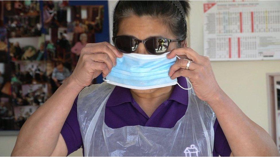 Nurse puts on personal protective equipment