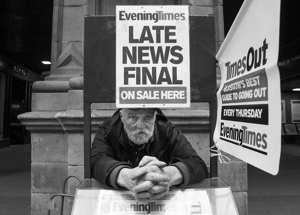 A vendor in the street outside Central Station, selling the Evening Times