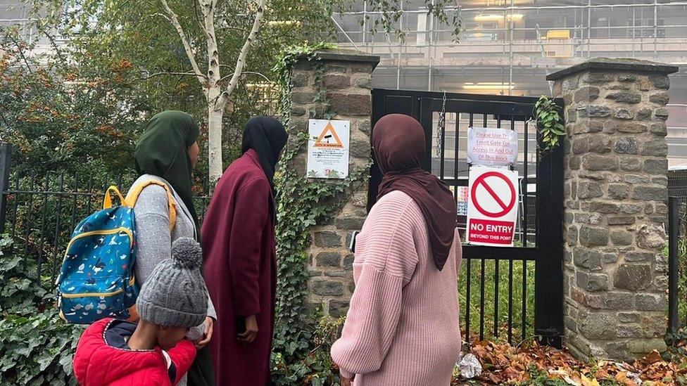 Four people looking at a wall