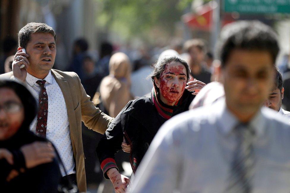 Injured Afghans run from the site of a blast in Kabul, Afghanistan 31 May 2017.