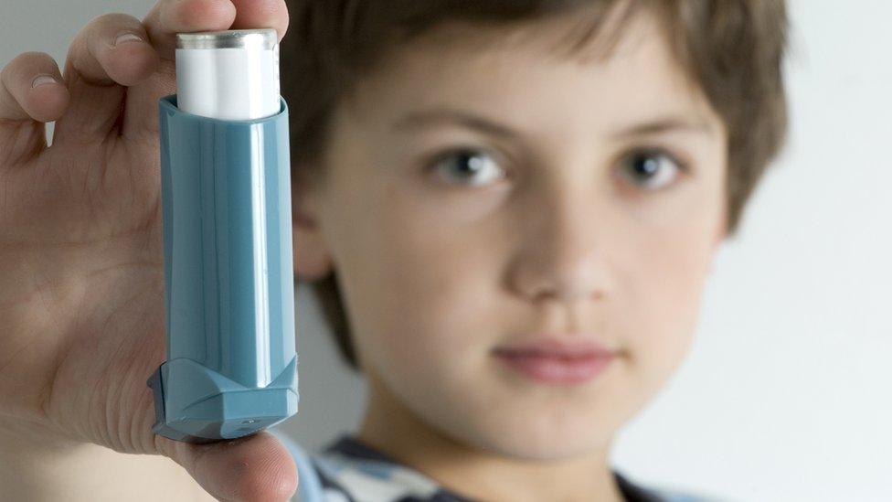 Boy-holding-blue-inhaler.