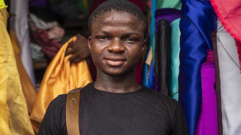 Man looking into camera with cloth in the background