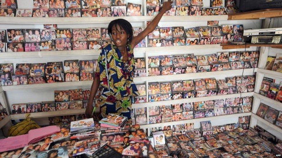 A sales girl attends to customers in a shop at the Nigerian film market in Lagos on 26 March 2010