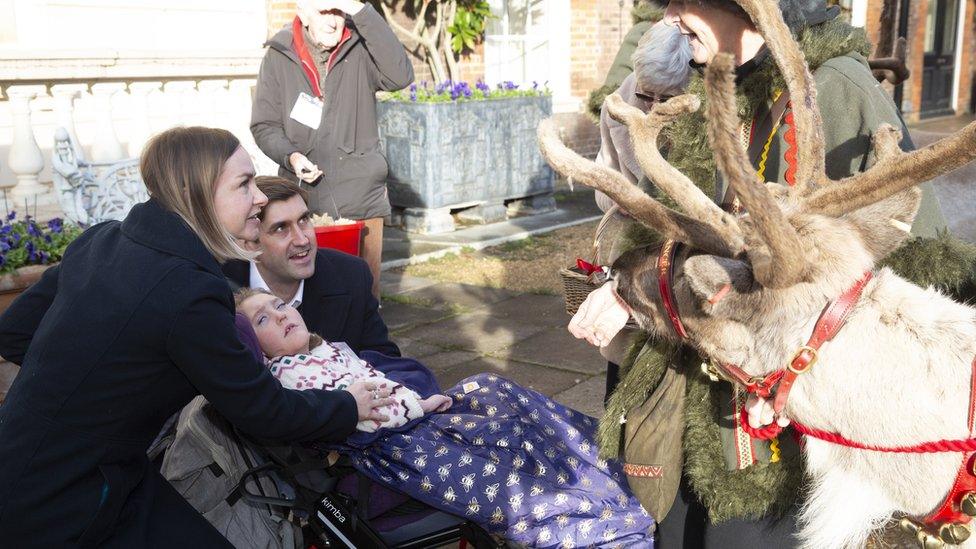 The Naden family and a reindeer outside