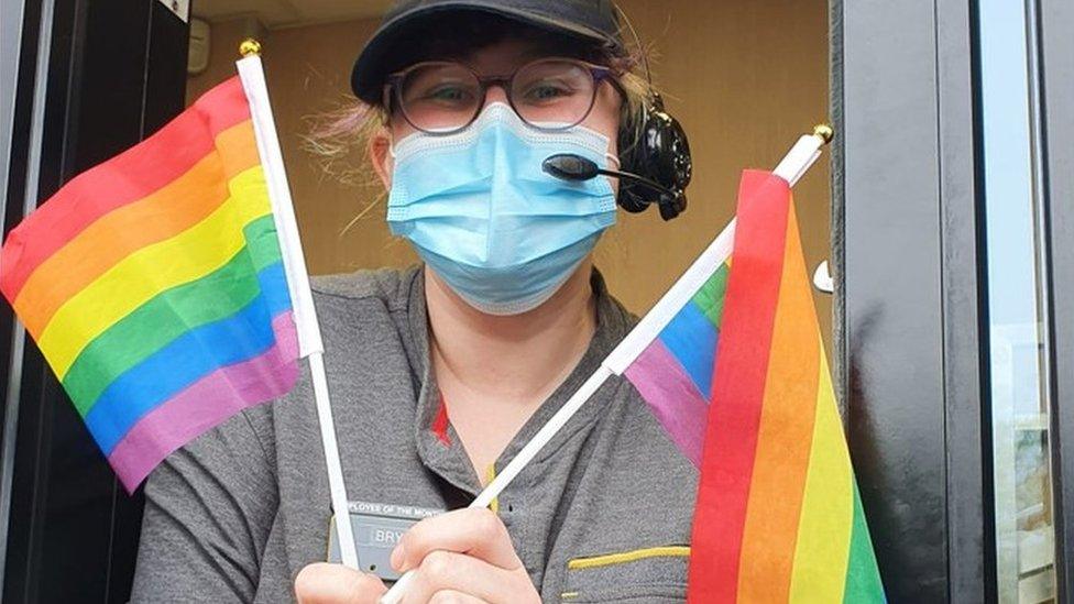 A woman waving Pride flags