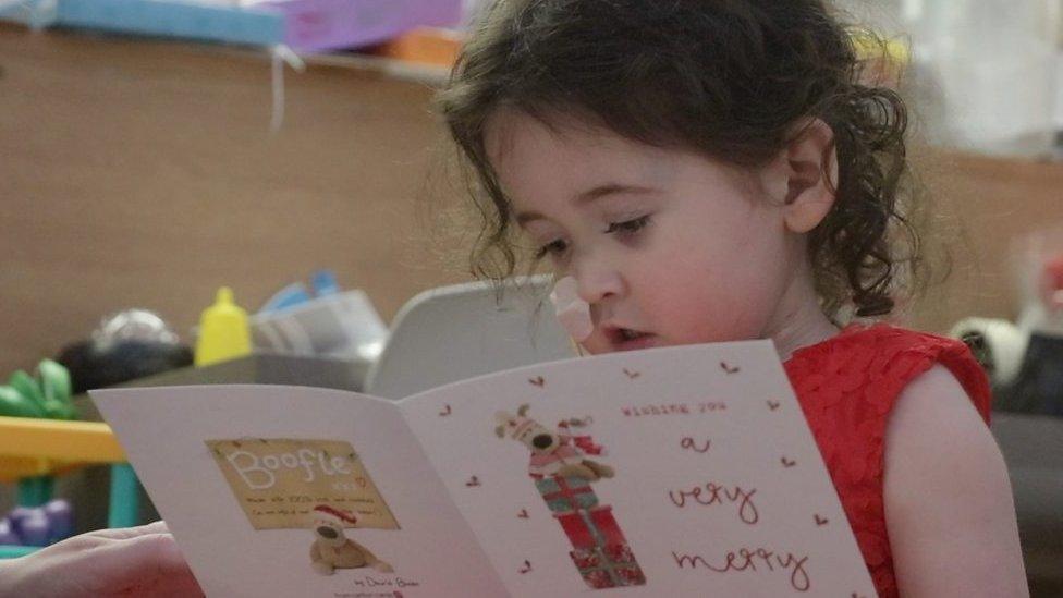 four-year-old Evie Green reading a Christmas card