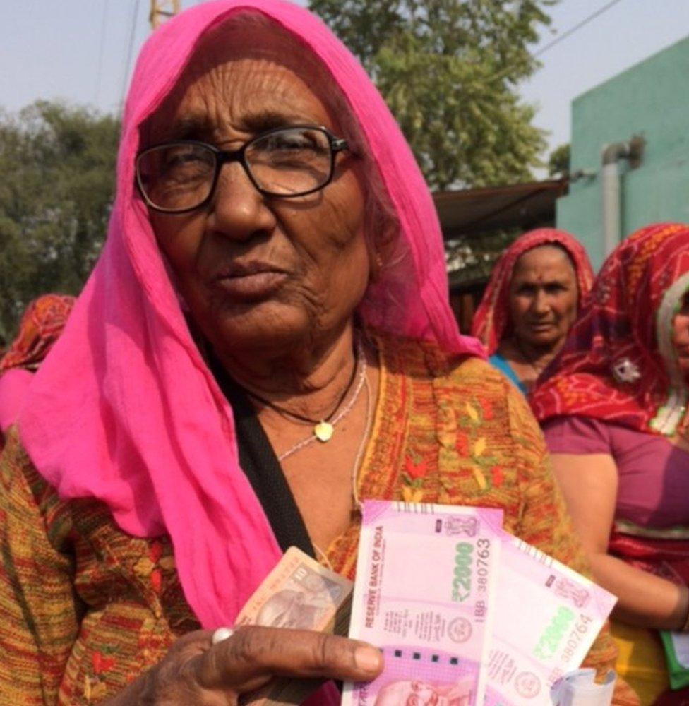 A woman displays some of the new notes